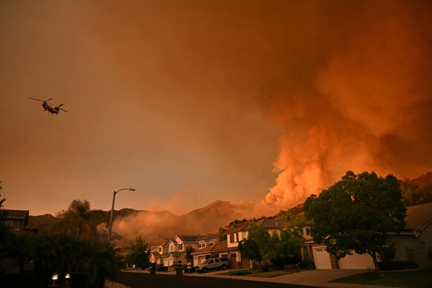 Smoke billows fabove a row of two story homes.