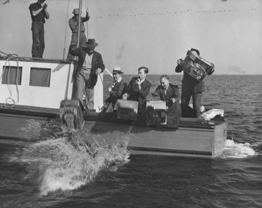Slot machines confiscated on the SS Rex gambling ship, are being tossed overboard into the sea.