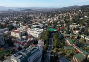An aeriel view of a college campus and town with lots of trees and greenery.