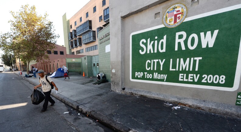 A sign reading 'Skid Row' is painted on a wall next to the Los Angeles Mission, September 22, 2014 in Los Angeles, California. Los Angeles' Skid Row contains one of the largest populations of homeless people in the United States