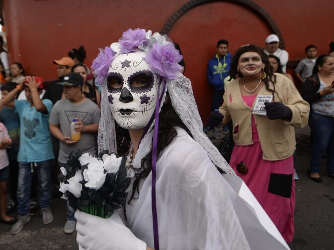 A woman dressed as Catrina takes part in the traditional Convite de fieros festival, as part of All Saints Day celebrations in Villa Nueva, Guatemala, on November 1, 2016.