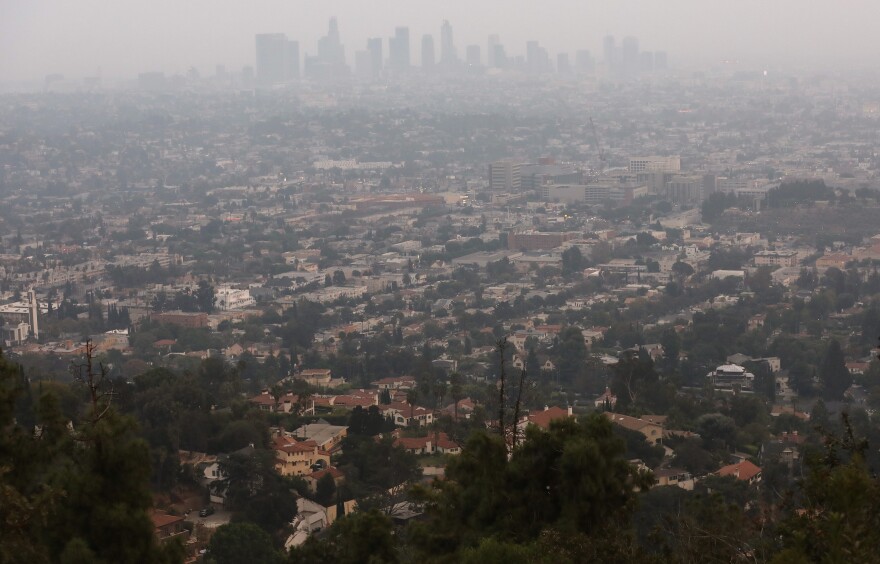 The downtown skyline partially obscured by smoke from wildfires after sunset.