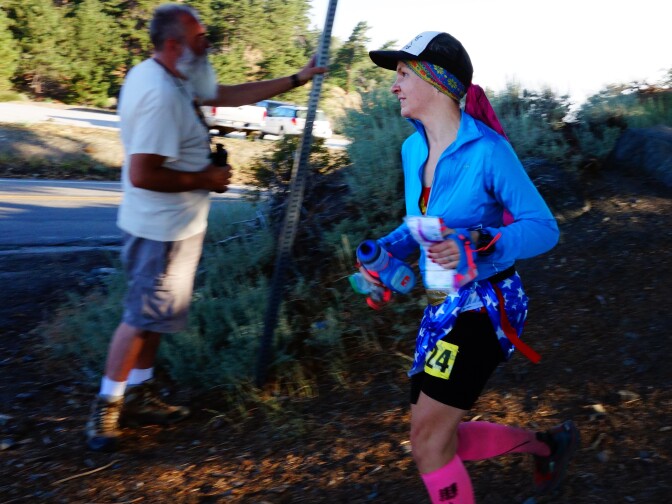                                Ultrarunner Martine Sesma runs into an Angeles Crest 100 aid station after completing nine miles of the 100-mile race from Wrightwood to Altadena.