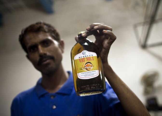 Pakistani worker Ansar poses with a bottle of whisky before packing at The Muree Brewery Company in Rawalpindi on July 13, 2010. The Murree Brewery company was established in 1860 to meet the beer requirements of British personnel (mainly army). Pakistan's oldest public company and the only brewery in this Islamic republic produces 60000 liters of Beer, 30000 liters of liquors, like whisky, Vodka and Gin and 100000 liters of non-alcoholic drinks and juices per year after 150 years in business. Only being allowed to sell to the non-Muslim three percent of the 170 million population as under the present prohibition law, only non-Muslims and foreigners are permitted to consume alcohol. The alcoholic production can not be exported to the other countries and non-Muslims can only buy from designated shops inside hotels in Islamabad and also from alcoholic shops in the local markets of Karachi and other cities of Sindh province.    