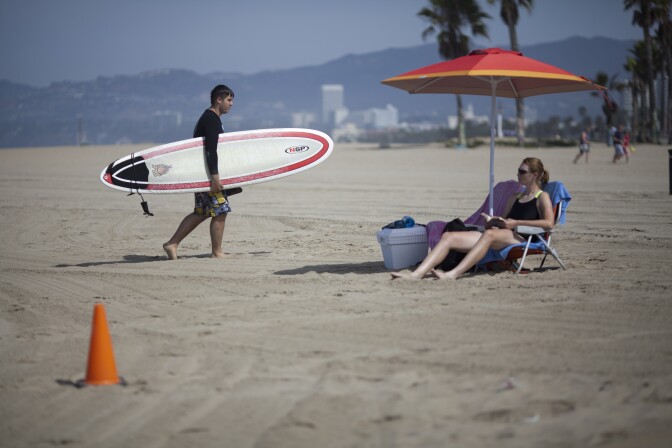 Beach goers soak in the morning sunshine on Venice beach a day after a rare lightning storm struck multiple people and killed one person who was swimming in the ocean at the time.
