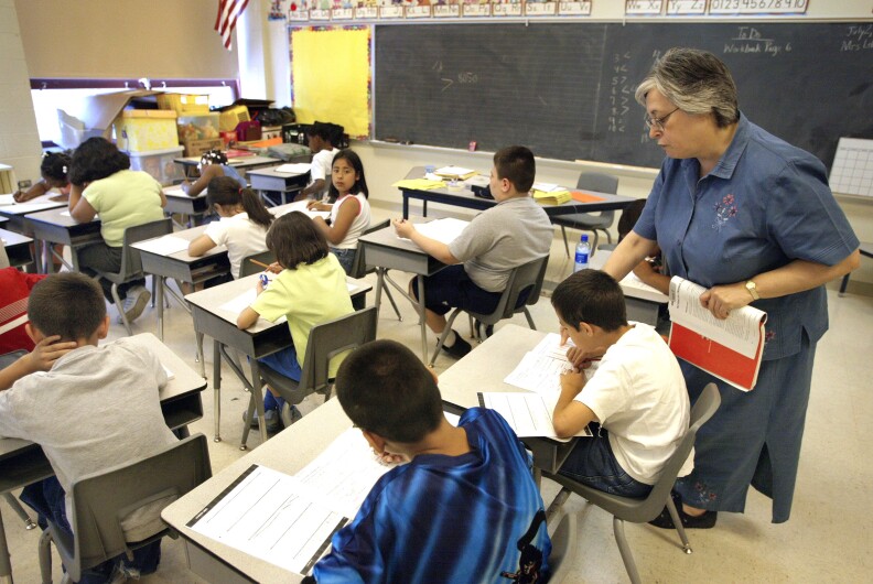 Teacher Arlene Lebowitz assists a student in her third-grade class during summer school July 2, 2003 in Chicago, Illinois.