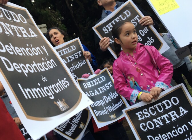A student holds a protest sign that translates to "Shield Against Detention and Deportation of Immigrants" at an anti-Trump rally organized by teachers unions at Mar Vista's Grand View Boulevard Elementary School on Thurs., Jan. 19, 2017.