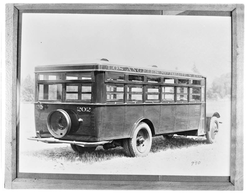 A framed photograph of a public bus from the 1920s.