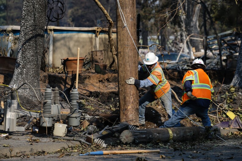 SANTA ROSA, CA - OCTOBER 13: PG&E workers work to repair power lines in the Coffey Park neighborhood following the damage caused by the Tubbs Fire on October 13, 2017 in Santa Rosa, California. Twenty four people have died in wildfires that have burned tens of thousands of acres and destroyed over 3,500 homes and businesses in several Northern California counties.  (Photo by Elijah Nouvelage/Getty Images)