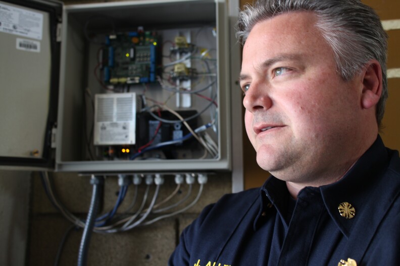 Palm Springs Fire Chief John Allen stands in front of the Seismic Warning Systems' early warning unit at his station. He says the instrument gives his firefighters crucial lead time in preparing for serious shaking.
