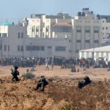 A picture taken on May 14, 2018 from the southern Israeli kibbutz of Nahal Oz across the border with the Gaza Strip shows Israeli soldiers keeping position and Palestinian protestors gathering along the border fence with Israel. - Dozens of Palestinians were killed by Israeli fire on May 14 as tens of thousands protested and clashes erupted along the Gaza border against the US transfer of its embassy to Jerusalem, after months of global outcry, Palestinian anger and exuberant praise from Israelis over President Donald Trump's decision tossing aside decades of precedent. (Photo by JACK GUEZ / AFP)        (Photo credit should read JACK GUEZ/AFP/Getty Images)