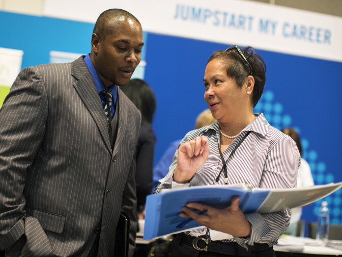 Lemar McClellan, left, speaks with Penny Torres, a human resources program manager with Los Angeles County, about open IT positions with the county during the Los Angeles Opportunity Hiring Fair on Thursday morning, Feb. 11, 2016.