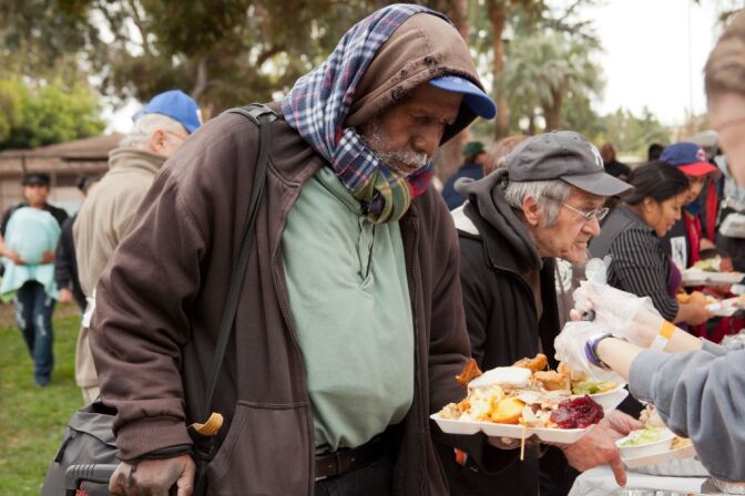 Mark Rice lines up to get a free  meal at Union Station Homeless Services' Thanksgiving dinner last year at Central Park in Pasadena. 