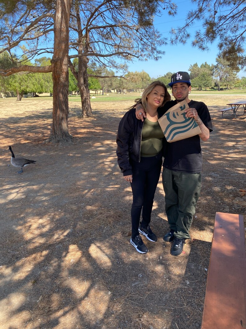 Vanessa and Joseph Perez stand with their arms around each other. Joseph wears a blue LA Dodgers hat.