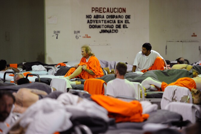 Inmates at Chino State Prison, which houses 5500 inmates, crowd around double and triple bunk beds in a gymnasium that was modified to house 213 prisoners on December 10, 2010 in Chino, California.