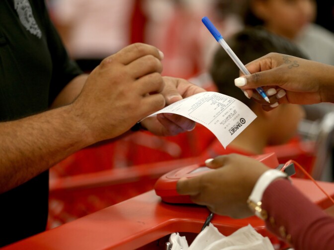 A customer prepares to sign a credit card slip Thursday at a Target store in Miami. The giant retailer says 40 million payment cards nationwide may have been compromised by data theft.