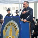 Los Angeles Police Chief Charlie Beck points to the black ribbon on his badge while addressing police recruits at their graduation ceremony on July 8, 2016 in Los Angeles, California as rappers Snoop Dogg and The Game led a peaceful demonstration outside in what they called an effort to promote unity in the aftermath of the deadly shootings of police officers in Dallas.

 / AFP / Frederic J. BROWN        (Photo credit should read FREDERIC J. BROWN/AFP/Getty Images)