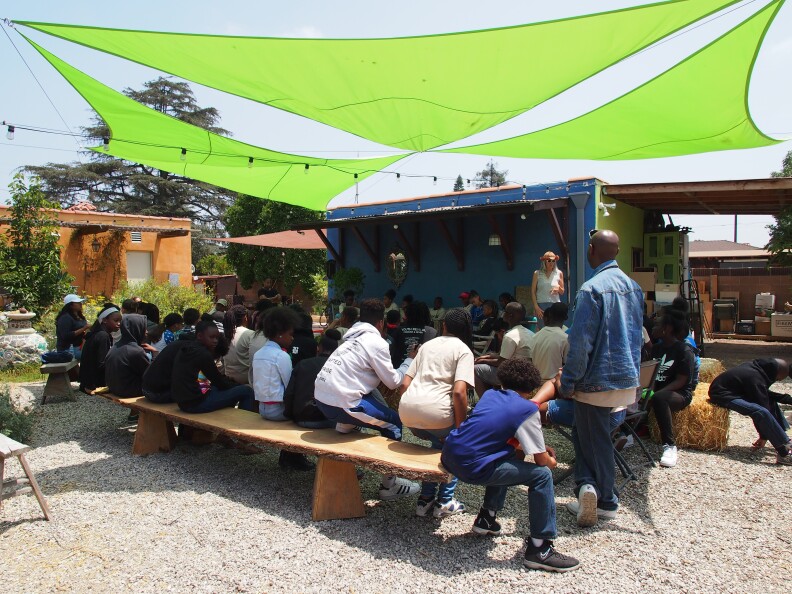 Students gather on the farm to learn about the growing vegetables. 