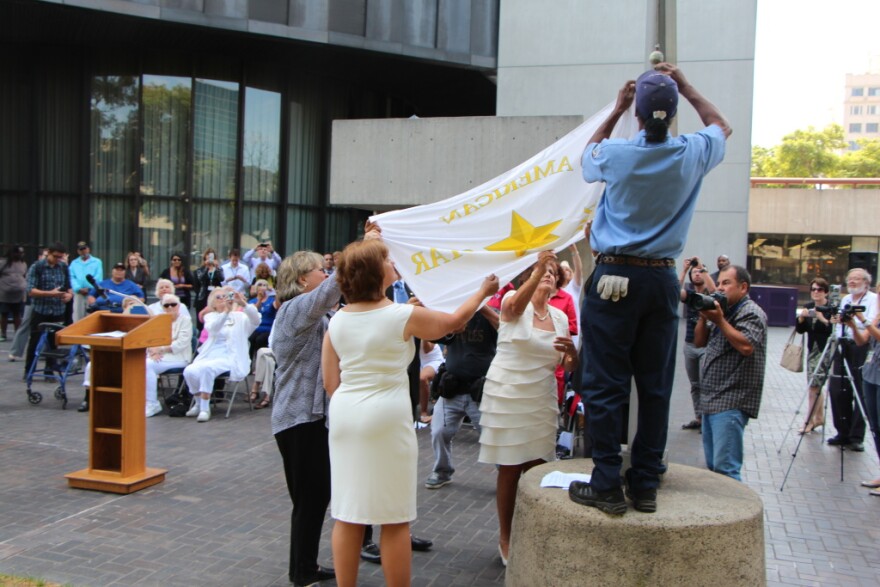 A flag honoring U.S. parents of military service members killed on duty during war is raised Aug. 15, 2013 at Long Beach City Hall Plaza. The women dressed in white are members of the American Gold Mothers, who have suffered the loss of a son or daughter in war.