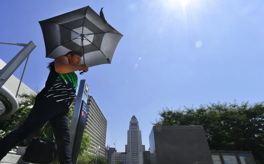 A view of someone walking outside using an umbrella to block the sun.