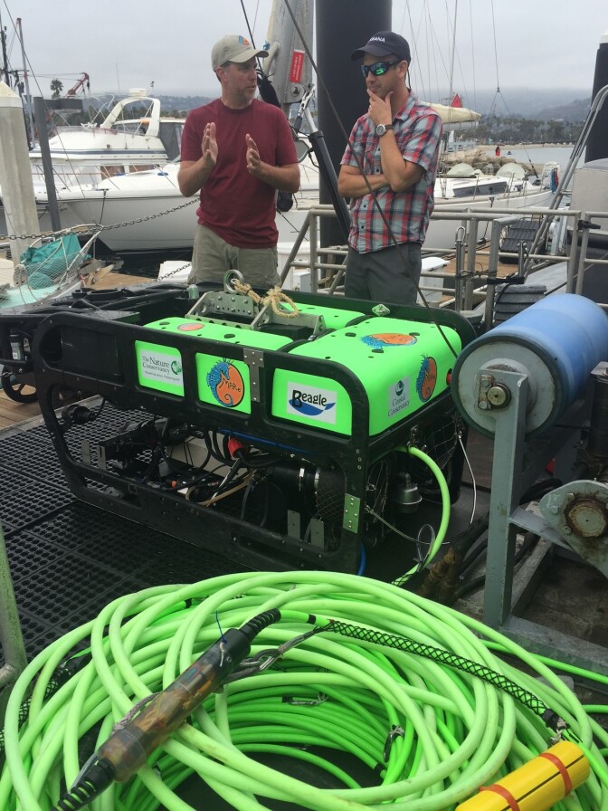 Ben Enticknap of Oceana and Dirk Rose of MARE stand next to the remotely operated underwater vehicle they'll use to map the ocean floor.