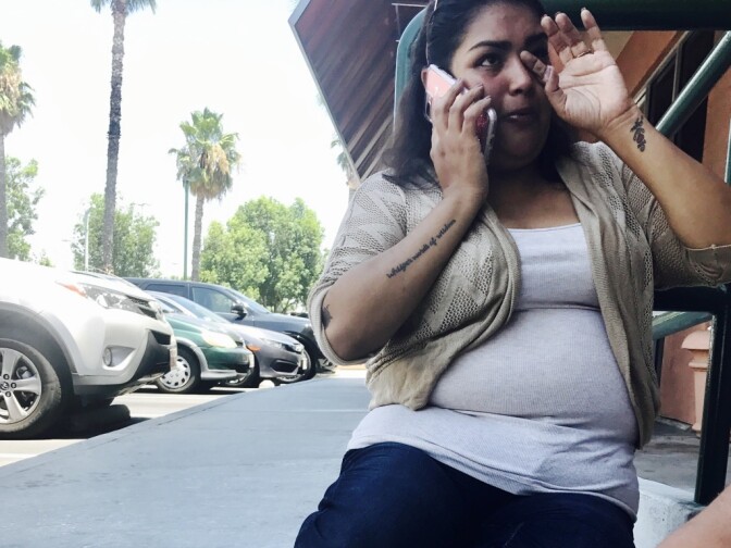 Helen Rivera, 35, sits on the floor in front of the Alfred Angelo store in West Covina, when she arrived to pick up her last bridesmaid dress and the store was unexpectedly closed.