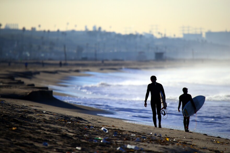 MARINA DEL REY, CA - JANUARY 25:  Surfers walk up the beach in Marina del Rey, California.  (Photo by Bruce Bennett/Getty Images)