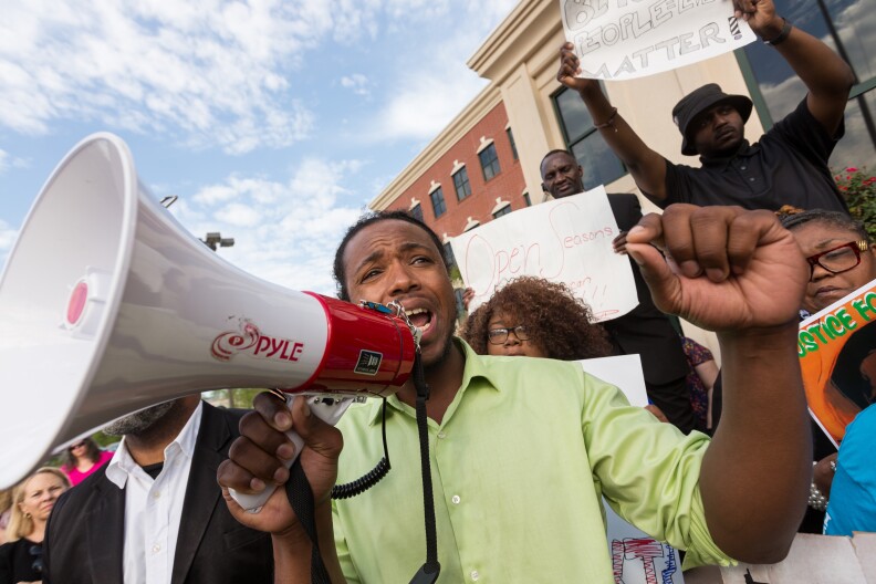 NORTH CHARLESTON, SC - APRIL 08:  People participate in a rally to protest the death of Walter Scott, who was killed by police in a shooting, outside City Hall on April 8, 2015 in North Charleston, South Carolina. Video captured by a bystander showed officer Michael Slager shooting Scott as he ran away. Officer Slager has been charged with murder as a result of the incident.  (Photo by Richard Ellis/Getty Images)