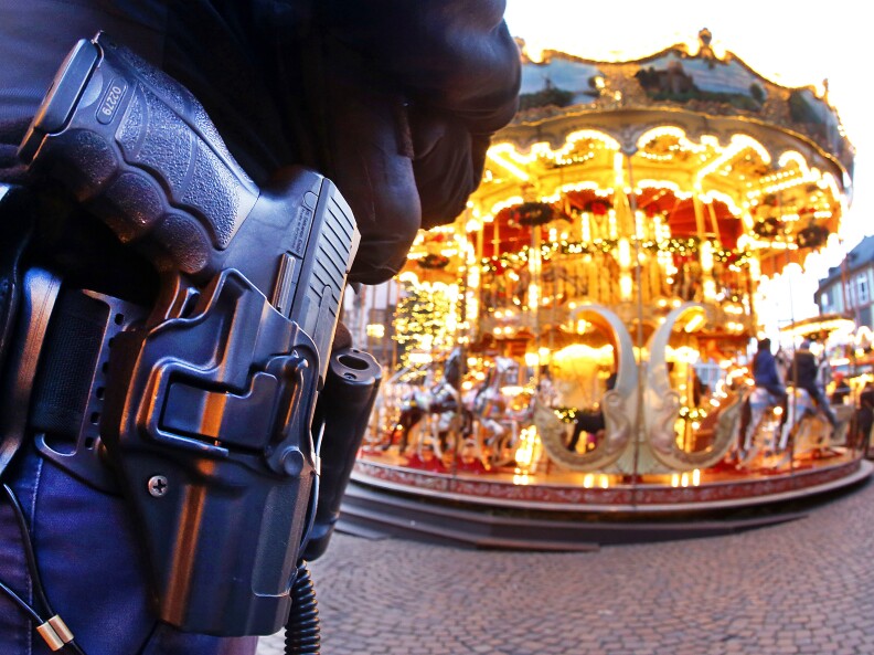 A German police officer stands next to a merry-go-round in the Christmas market in Frankfurt, Germany, Tuesday, Dec. 20, 2016 one day after a truck ran into a crowded Christmas market in Berlin killing several people. (AP Photo/Michael Probst)