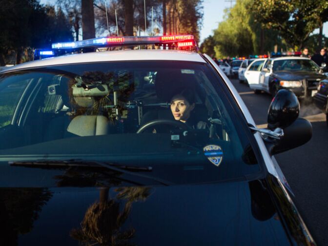 Officer Velazquez prepares for the procession from Acheson and Graham Mortuary to the Grove Community Church for Michael Crain's funeral.