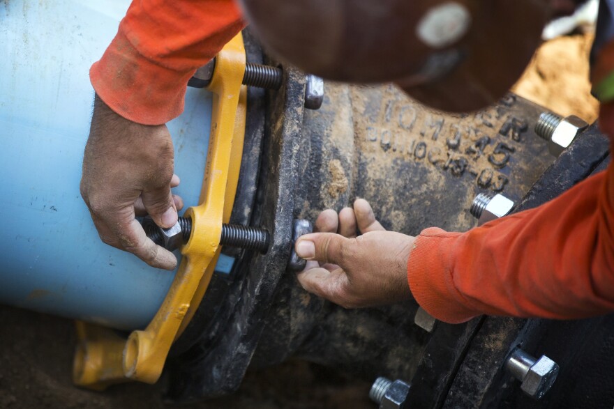 California City Department of Public Works employees install new water pipe pieces in California City on Monday, July 11, 2016. “The bottom line is money," said Mayor Jennifer Woods. "If you dropped half a billion dollars on me, we could do a whole lot with half a billion dollars. But we’re not wealthy.”