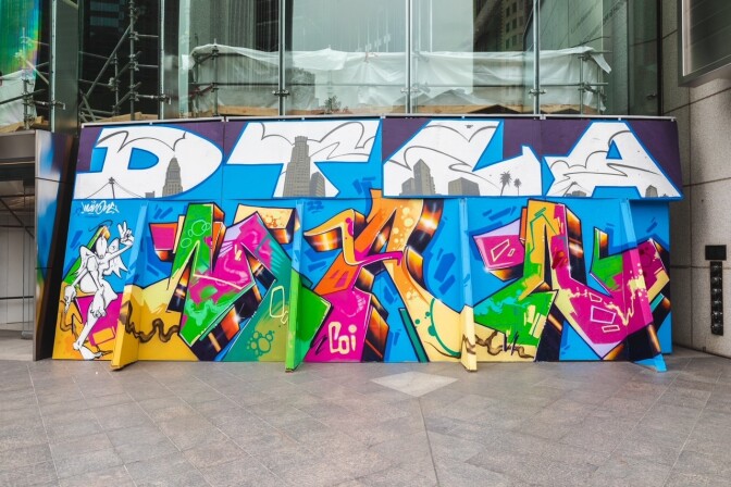A colorful graffiti art mural on a wall. Large, white letters across the top spell DTLA for Downtown Los Angeles.