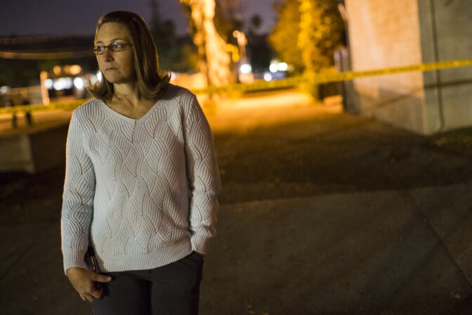 Gayle Perez, who lives on Center Street, waits near Center Street at Pine Avenue on Wednesday night, Dec. 2, 2015 as authorities serve a search warrant following a mass shooting inside the the Inland Regional Center in San Bernardino on Wednesday, Dec. 2, 2015.