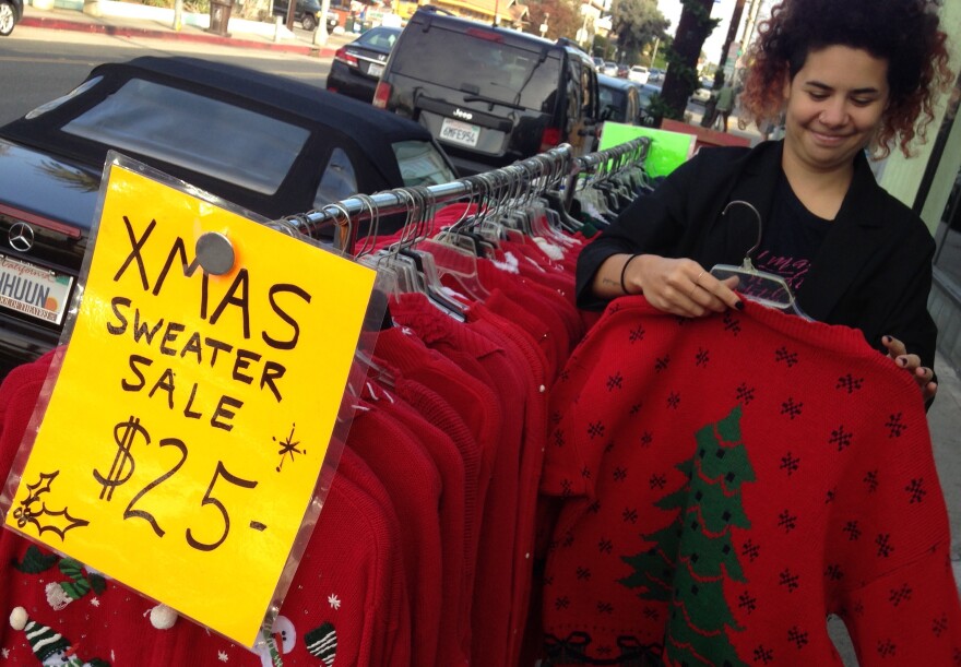 "Sugar PoleNorth" browses through a collection of ugly Christmas sweaters outside of the Sneaky Tiki in Long Beach. 