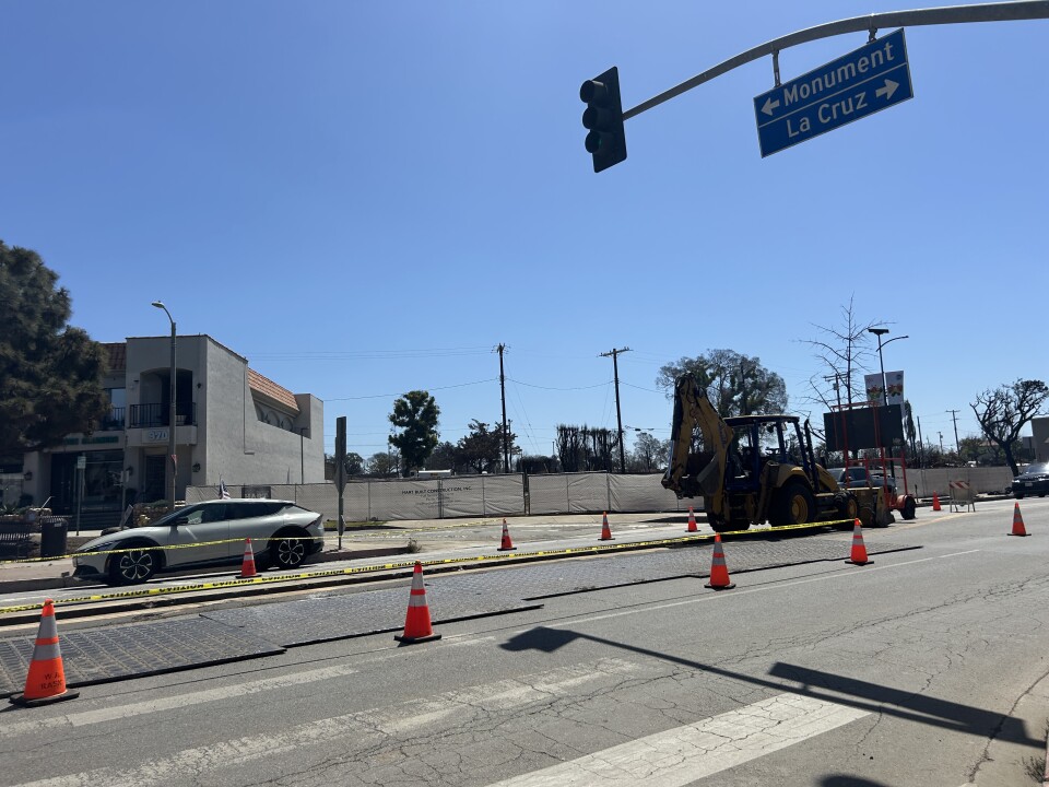 A street under construction on a sunny day. 