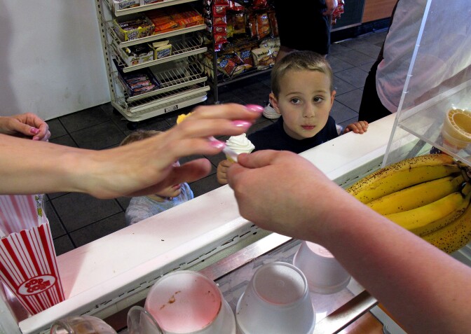4-year-old Gavin Rivera watches an ice cream shop clerk in Belmar N.J., hand his mother a free sample. Business owners along the Jersey shore say the unseasonably warm spring has boosted their business levels by as much as 30 percent over what they normally would be at this time of year. 