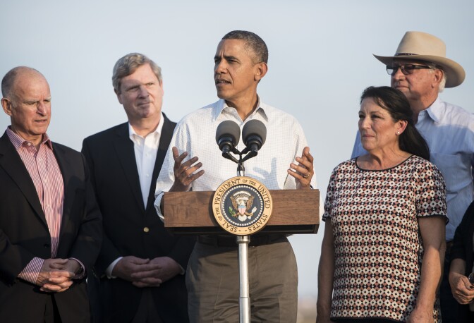 California Governor Jerry Brown (L), Joe Del Bosque (2L) and Senator Barbara Boxer (D-CA) (R) listen while US President Barack Obama speaks after touring the Empresas Del Bosque, Inc. farm February 14, 2014 in Los Banos, California. Obama is visiting the Fresno area where he will speak with members of the community and tour drought effected areas.