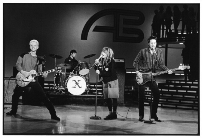 Black and white photo of four musicians playing on stage at American Bandstand.