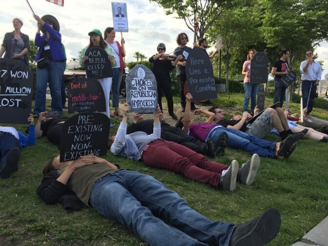 Protesters display makeshift tombstone signs at "die-in."