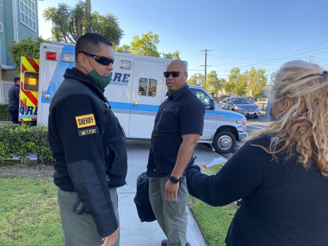 MET Deputy Joe Miranda (L) debriefs after responding to a crisis call in Baldwin Park. 