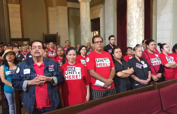 Hospitality workers with Unite Here Local 11 stand up as members call for tighter regulations on Airbnb and other short-term rental companies at a Los Angeles City Council planning committee meeting on June 13, 2017.