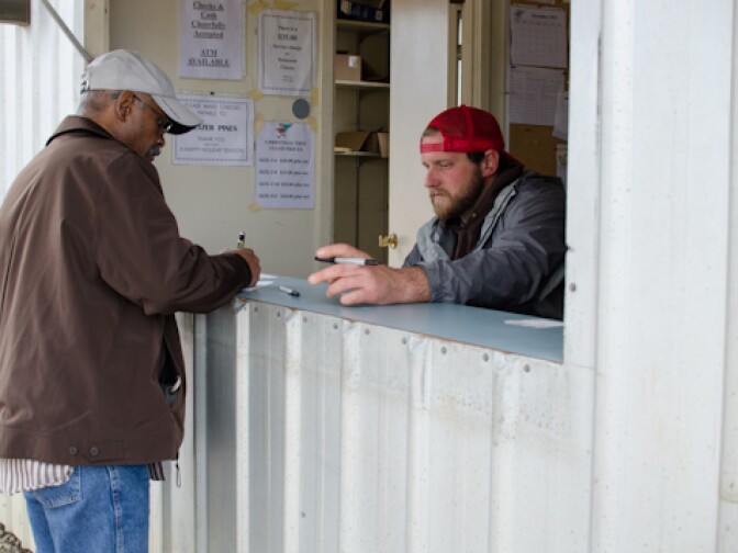 M. Johnson, left, of Diamond Bar pays Andrew Miles of Peltzer Pines for his Christmas tree in Brea, Calif., Wednesday, Dec. 12, 2012.