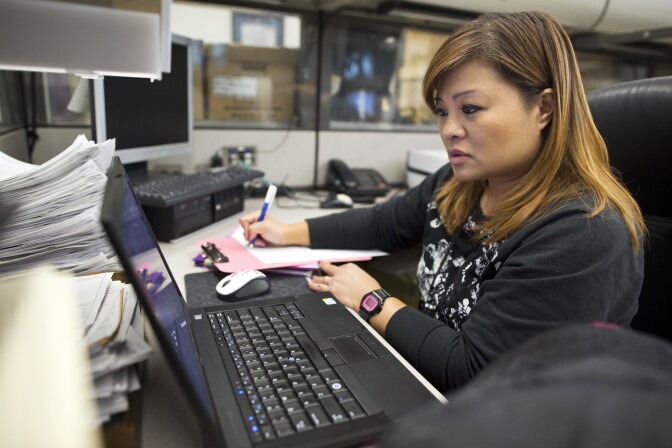 Grace Bescoby, a registered nurse and mental health counselor on the Mental Evaluation Unit's SMART team, looks for possible hospitals where the man in custody could be taken in at the LAPD's Rampart Division on Thursday, Dec. 11, 2014.