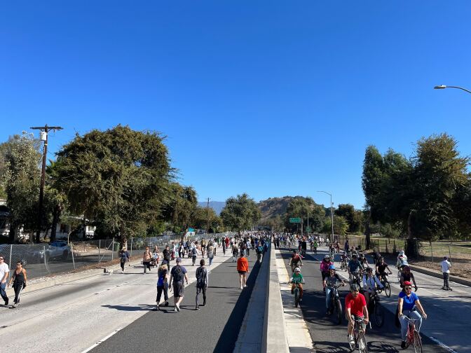Dozens of bikers, skateboarders and pedestrians on the 110 freeway.