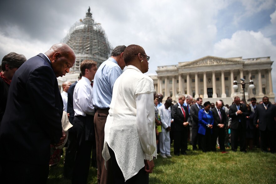 WASHINGTON, DC - JUNE 18: Rep. John Lewis (D-GA) (L) joins members of the US House of Representatives and members of the US Senate in a prayer circle in front of the US Capitol to honor those gunned down last night inside the historic Emanuel African Methodist Episcopal Church in Charleston South Carolina, June 18, 2015 in Washington, DC. Police have arrested Dylann Roof, 21, of Lexington, South Carolina in the shooting that killed 9 people. (Photo by Mark Wilson/Getty Images)