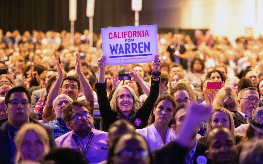A woman holds up a sign showing support for Democratic presidential candidate for Elizabeth Warren as she speaks on stage during the 2019 California Democratic Party State Convention at Moscone Center in San Francisco on June 1, 2019. (Photo by Josh Edelson / AFP)        (Photo credit should read JOSH EDELSON/AFP/Getty Images)