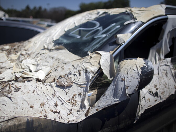 Debris covers a car damaged in a flooded parking garage after a water main broke and spilled 20 million gallons of water on the UCLA campus.
