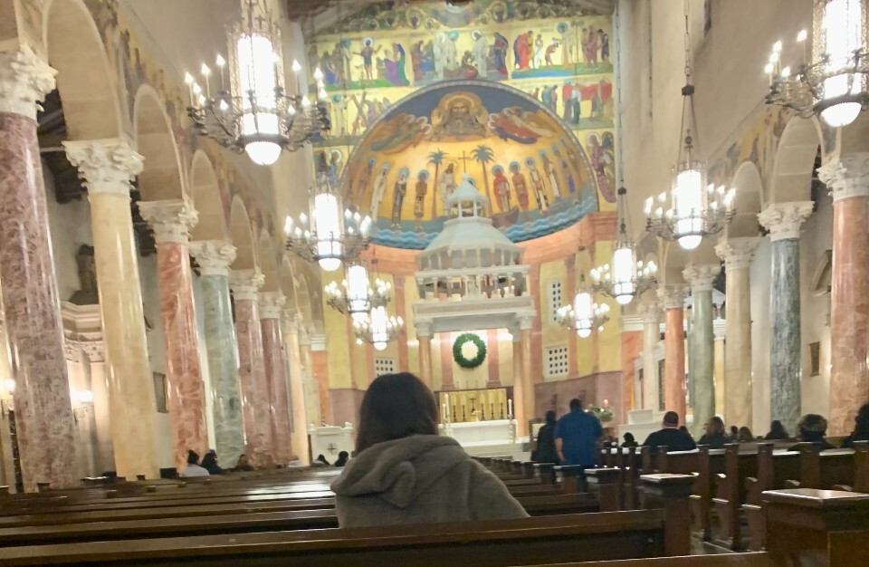 A view of the interior of St. Andrew Church -- filled with multicolored columns and colorful murals -- from a back pew.