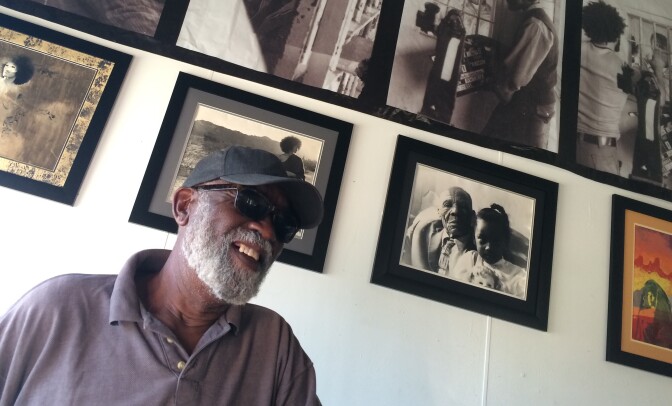 Ben Caldwell, a key figure in the L.A. Rebellion black cinema movement in the 1970s, at the KAOS Network studio in Leimert Park. He stands before photographs he took during that era.
