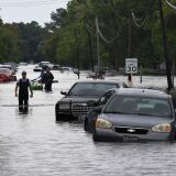 TOPSHOT - Local residents wade through flooded streets after Hurricane Harvey caused heavy flooding in Crosby, Texas on August 30, 2017.  
Monster storm Harvey made landfall again Wednesday in Louisiana, evoking painful memories of Hurricane Katrina's deadly strike 12 years ago, as time was running out in Texas to find survivors in the raging floodwaters. / AFP PHOTO / MARK RALSTON        (Photo credit should read MARK RALSTON/AFP/Getty Images)